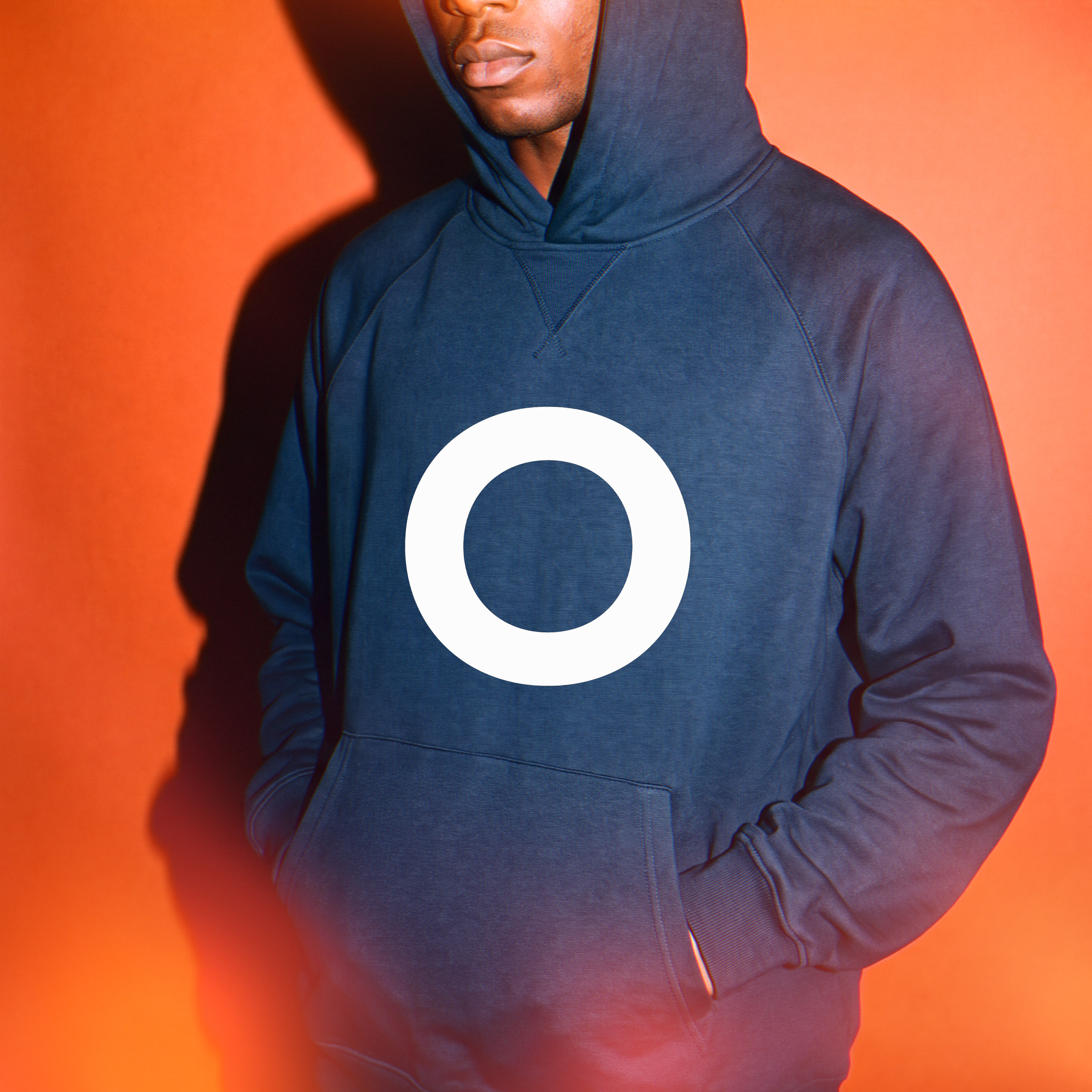 After Grade Issue:01 — navy hoodie with the ring mark, hard flash on orange